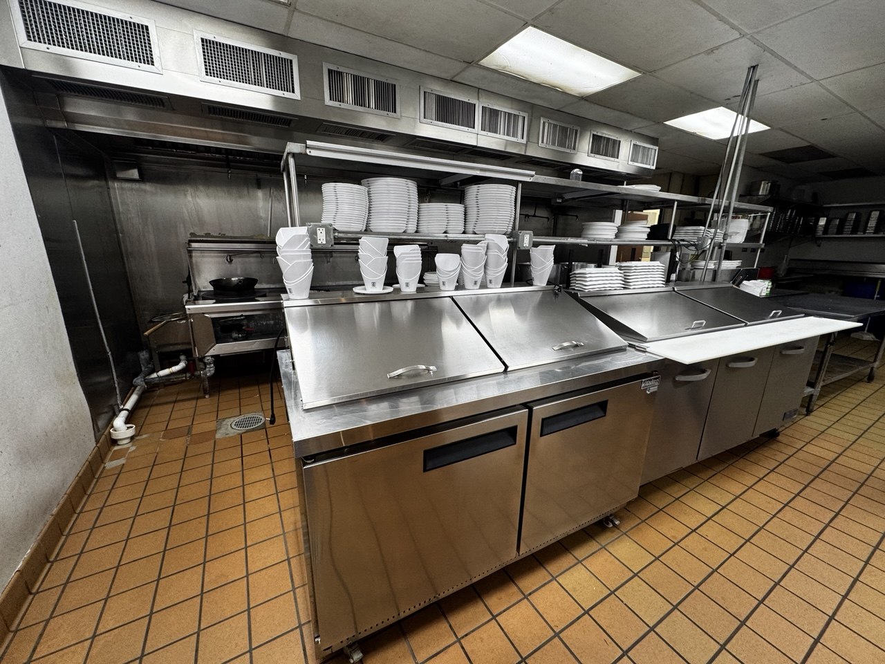 Restaurant prep tables refrigeration and smallwares staged for auction